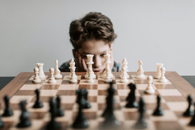 A boy studying a chess board